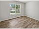 Sunlit bedroom with wood-look tile flooring and a large window offering a serene view, ready for customization at 1634 Dawson Ct, Rock Hill, SC 29730