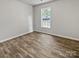 Neutral bedroom has hardwood floors and a bright window with views of the yard at 1634 Dawson Ct, Rock Hill, SC 29730