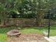 Scenic backyard featuring a new horizontal fence, a fire pit, and lush landscaping at 2113 Ballingarry Dr, Statesville, NC 28625