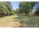 A large, expansive backyard featuring a picnic table surrounded by many large trees at 2508 Wood Star Ct, Matthews, NC 28105