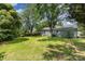 Large backyard with healthy grass and mature trees and the exterior back of the home at 3015 Lasalle St, Charlotte, NC 28216