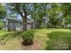 The backyard offers a large grassy area shaded by mature trees, perfect for outdoor activities at 3015 Lasalle St, Charlotte, NC 28216