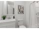 Modern bathroom with a white vanity, toilet, shower with curtain, and an updated mirror at 3015 Lasalle St, Charlotte, NC 28216