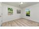 Bright bedroom featuring wood-look flooring, two windows, fresh white paint, and a modern art piece at 3015 Lasalle St, Charlotte, NC 28216