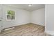 Bright bedroom featuring wood-look flooring, a window, fresh white paint, and recessed lighting at 3015 Lasalle St, Charlotte, NC 28216