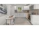 Stylish kitchen featuring white cabinets, gray backsplash, stainless steel appliances, and modern fixtures at 3015 Lasalle St, Charlotte, NC 28216