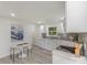 Modern kitchen featuring white cabinets, gray backsplash, stainless appliances, and gray wood-look flooring at 3015 Lasalle St, Charlotte, NC 28216