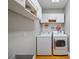 Bright laundry room with white washer and dryer, storage cabinets, and pegboard organizer at 630 4Th Nw Ave, Hickory, NC 28601