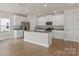 Well-lit kitchen showcasing stainless appliances, white cabinets, and a granite island at 7007 Jerimoth Dr, Charlotte, NC 28215