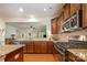 Modern kitchen featuring stainless steel appliances, granite countertops and dark wood cabinets at 7015 Gracefield Ln, Fort Mill, SC 29707