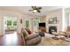 Comfortable living room featuring a fireplace, ceiling fan, and access to outdoor areas, ideal for relaxation at 7015 Gracefield Ln, Fort Mill, SC 29707