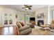 Comfortable living room featuring a fireplace, ceiling fan, and access to outdoor areas, ideal for relaxation at 7015 Gracefield Ln, Fort Mill, SC 29707