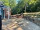 Backyard brick patio and flower beds next to a manicured lawn and mature trees at 1320 Kings Cir, Shelby, NC 28150