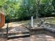 Backyard brick patio with mature trees, landscaping, and a waterfall feature on a bright day at 1320 Kings Cir, Shelby, NC 28150