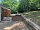 A brick patio area is showcased, with a brick-retaining wall and a view of the mature trees and greenery beyond at 1320 Kings Cir, Shelby, NC 28150