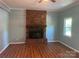Inviting living room with a brick fireplace and wood-look flooring, perfect for cozy evenings at 1320 Kings Cir, Shelby, NC 28150