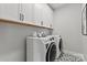 Laundry room with front load machines, upper cabinets, and a stylish tile floor at 143 Goorawing Ln, Mooresville, NC 28115