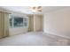 Bright bedroom featuring a large window, neutral carpet, and a ceiling fan at 238 Pointe Cir, Rock Hill, SC 29732