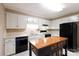 Well-lit kitchen with white cabinets, black appliances, an island and modern fixtures at 238 Pointe Cir, Rock Hill, SC 29732