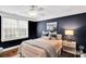Dark-walled bedroom with a ceiling fan, bright white trim, and warm-colored bed at 4552 Sawgrass Ct, Denver, NC 28037