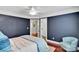 This bedroom features striking navy blue walls, hardwood floors, and a modern ceiling fan at 4552 Sawgrass Ct, Denver, NC 28037