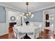 Dining room with modern chandelier, white chairs, and views into other rooms at 4552 Sawgrass Ct, Denver, NC 28037