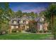 Charming two-story home with manicured lawn, stone accents, red shutters, and lush landscaping at 4552 Sawgrass Ct, Denver, NC 28037