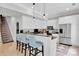 Modern white kitchen with stainless steel appliances, breakfast bar seating, and granite countertops at 4552 Sawgrass Ct, Denver, NC 28037