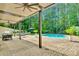 Covered patio with ceiling fans, dining table, grill, and lounge seating by the pool at 4552 Sawgrass Ct, Denver, NC 28037
