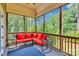 Screened in porch with comfortable seating and views of the serene, wooded backyard at 4552 Sawgrass Ct, Denver, NC 28037