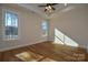 Bright bedroom with hardwood floors, tray ceiling, ceiling fan, and two windows at 1524 Conestoga Xing, Catawba, NC 28609