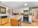 Well-lit kitchen with white cabinets, black range, and colorful tiled backsplash at 225 Shore Acres Rd, Salisbury, NC 28146