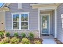 Close up of a home's entryway featuring a blue door with sidelight and a Kolter welcome mat at 6043 Waldorf Ave, Monroe, NC 28110