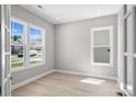 Sun-filled living room with wood-look flooring and large windows offering great natural light and neighborhood views at 6043 Waldorf Ave, Monroe, NC 28110