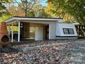 Exterior view of the living structure featuring a covered deck, outdoor seating, and a well-maintained camper at 112 Sycamore St, New London, NC 28127