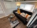 Comfortable living room with a black futon, accent pillows, stylish rug, and natural light streaming in through the windows at 112 Sycamore St, New London, NC 28127