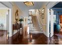 Inviting foyer with hardwood floors, detailed wallpaper, elegant staircase, and stylish decor at 4016 Nettie Ct, Charlotte, NC 28211