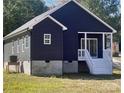 Rear view of a charming home featuring dark siding and a cozy covered porch with white railings at 213 Sheffield Dr, York, SC 29745