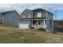 Charming two-story home with gray siding, a white garage door, and a welcoming front porch at 117 High Rock Ct # 09, Statesville, NC 28677