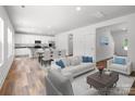 Bright, open-concept living space with white furniture flowing into the dining and kitchen areas at 169 Salem Springs Ln, Statesville, NC 28625