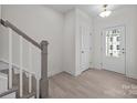 Bright entryway featuring light wood flooring, a staircase with gray handrail, and a glass-paneled front door at 4227 Alexander View Dr # 35, Charlotte, NC 28226