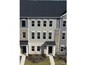 Three-story townhome featuring brick and gray siding, complete with black shutters and a covered entryway at 4225 S New Hope Rd # 9, Cramerton, NC 28032