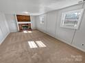 Open living room with brick fireplace, neutral carpet, and natural light at 1006 Wilson Blvd, Dallas, NC 28034