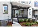 A covered front porch with room for seating is the focal point of this townhome at 413 Prine Pl # Brx0014, Charlotte, NC 28213