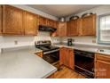 Functional kitchen featuring wood cabinets, black appliances, and ample counter space for cooking at 166 Rosalind Ln, Statesville, NC 28677