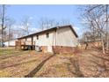 View of the back exterior of the home featuring a deck and well-kept yard, perfect for outdoor enjoyment at 1302 Hickory Nut Ln, Lincolnton, NC 28092