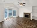 Bright living room with a cozy fireplace, built-in shelves, and large windows for natural light at 7210 Morningdew Ct, Denver, NC 28037