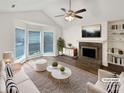 Bright living room with a cozy fireplace, modern furniture, and large windows for natural light at 7210 Morningdew Ct, Denver, NC 28037