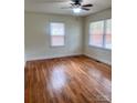 Spacious bedroom with hardwood floors and ample natural light from two windows at 3918 Barlowe Rd, Charlotte, NC 28208