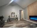 Cozy living room featuring a vaulted ceiling, modern fireplace and wood-look floors at 235 E Moore St, Rock Hill, SC 29730